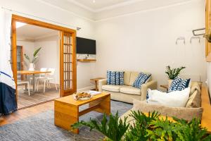 a living room with a couch and a table at Camps Bay Village - Stone Cottages in Cape Town