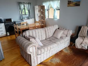 a living room with a couch and a table at Dream View Mountain Cabin in Durban