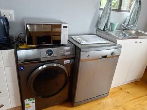 a kitchen with a washing machine and a microwave at Dream View Mountain Cabin in Durban