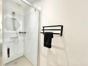 a white bathroom with a shower and a glass door at L'Esplanade - Confort & Lumineux in Mont-de-Marsan +14 photos