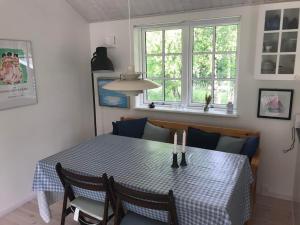 a dining room table and chairs with a blue and white checkered table cloth at Only 400 Meters From The Water Is This Lovely And Cozy Holiday Home In A Lovely Area, in Hundested +25 photos
