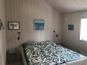 a bedroom with a bed with a comforter on it at Only 400 Meters From The Water Is This Lovely And Cozy Holiday Home In A Lovely Area, in Hundested
