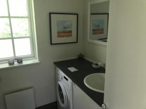 a bathroom with a sink and a washing machine at Only 400 Meters From The Water Is This Lovely And Cozy Holiday Home In A Lovely Area, in Hundested