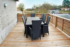 a wooden deck with a table and chairs on it at Amazing Home In Rudkøbing With 6 Bedrooms And Wifi in Spodsbjerg