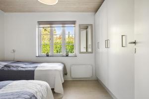 a bedroom with two beds and a window at Holiday Home With A Wilderness Bath, Only 100 Meters From The Lovely Beach in Marielyst