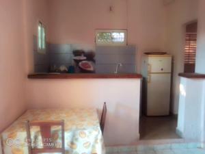 a kitchen with a counter and a table and a refrigerator at Appartement F2 50m2 centre ville sécurisé in Antsiranana