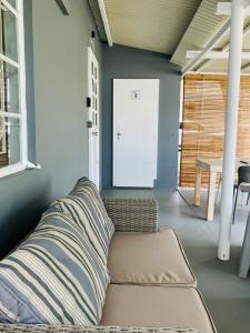 ein Sofa in einem Zimmer mit einem Tisch und einer Tür in der Unterkunft Lakaz Kokas in Pereybere