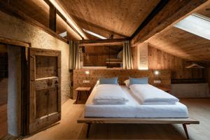 a large bed in a room with wooden ceilings at OBERBUCHFELDER historic farmhouse in Laion