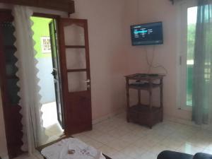 a living room with a door and a television at Appartement F2 50m2 centre ville sécurisé in Antsiranana