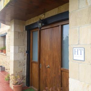a wooden door to a house with a sign on it at Solapetxea Habitación con Sauna in Elosu