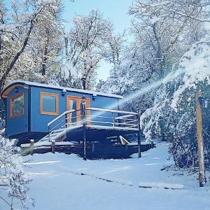 a blue train is covered in snow at Dos Tiny Houses con Vista Espectacular, 2 Baños y Bosque Privado para 2 Parejas in San Martín de los Andes