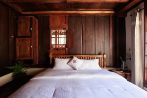 a bedroom with a large bed with wooden walls at Marmaram Heritage in Vagamon