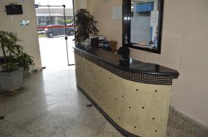 a reception desk in a lobby with a mirror at Aero Plaza Hotel in Sao Paulo