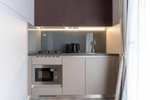 a small kitchen with a stove and a microwave at EuroParcs Ossiacher See in Ossiach