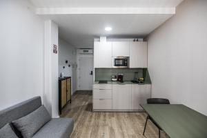 a kitchen with a couch and a table in a room at Apartamentos Luxury en San Juan in Badajoz