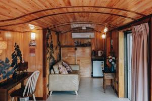 un salon avec des murs et un plafond en bois dans l'établissement UHAUS Train Cabin Resort, à Ban Sai Yok