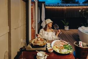 une femme assise à une table avec une assiette de nourriture dans l'établissement UHAUS Train Cabin Resort, à Ban Sai Yok 18 autres photos