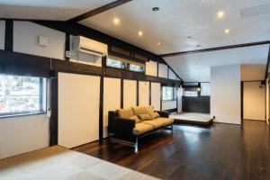 a living room with a couch in a room at 源泉掛け流し温泉Villa The ITAYA in Yuzawa