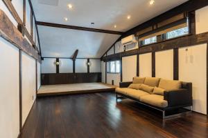 a living room with a couch and a stage at 源泉掛け流し温泉Villa The ITAYA in Yuzawa