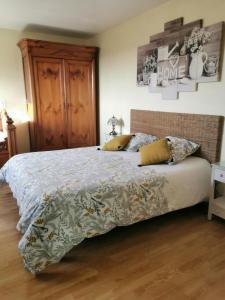a bedroom with a large bed with a wooden floor at Chambre d'hôtes Le Pot au Lait in Villaines-la-Juhel