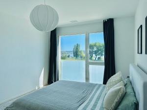 En eller flere senger på et rom på Stylisches Ferienhaus bis 6 Gäste mit einzigartigem Seepanorama