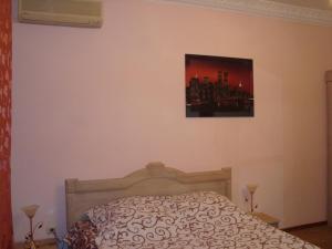 ザポリージャにあるApartment on Mira Centerのベッドルーム1室(ベッド1台付)が備わります。壁に絵が飾られています。