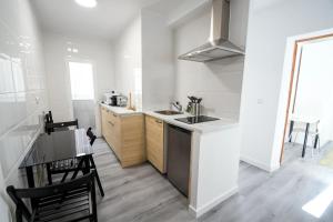 a white kitchen with a sink and a table at A 5 min del Aeropuerto e IFEMA in Madrid