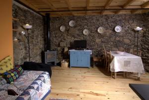 - un salon avec une table et un mur en pierre dans l'établissement Palheiros do Castelo, à Sabugal