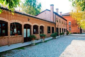 un bâtiment en briques avec des plantes en pot devant lui dans l'établissement Agriturismo Villa Mocenigo, à Mirano