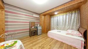 a small room with a bed and a table at Anmyeondo paradise pension in Taean +6 photos