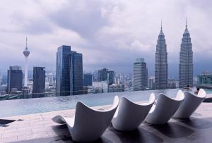 eine Gruppe weißer Stühle auf einem Gebäude in der Unterkunft Imperial KLCC Residence in Kuala Lumpur