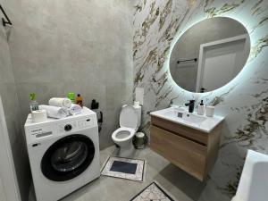 Un baño con lavadora y lavabo. en Arena Park, en Astana