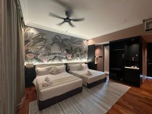 a bedroom with two beds and a ceiling fan at The Palm Suite Tanjung Tokong in George Town