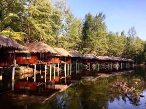 a group of huts on the water with trees at Sea Rounding in Ko Phra Thong