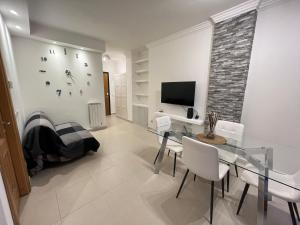 罗马Lele e Fede's Lodge & Relax的一间带玻璃桌和电视的用餐室