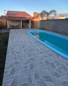 una piscina en un patio al lado de una casa en Casa de praia com piscina, en Río Grande