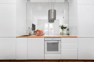Una cocina con gabinetes blancos y encimera. en Belles Bondi Beach Apartments - 1 and 2 Bedroom Stays - 500m to beach, en Sídney