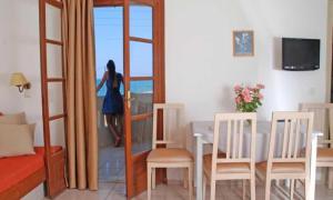 a woman is looking out the window of a room at John Mary Apartments by Estia in Gouves +17 photos