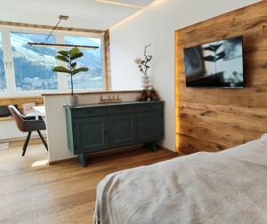 a bedroom with a green dresser and a tv on a wall at Alpenblick - klein, aber fein in Schladming