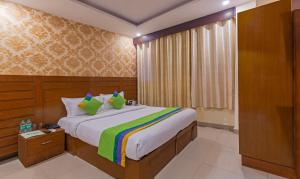 a bedroom with a large bed with a colorful blanket at Treebo Green View, Noida in Indirapuram