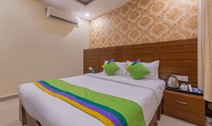 a bedroom with a large bed with a colorful blanket at Treebo Green View, Noida in Indirapuram