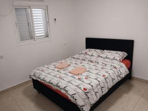 a bedroom with a bed with two boxes on it at דירה משפחתית מרווחת in Ashkelon