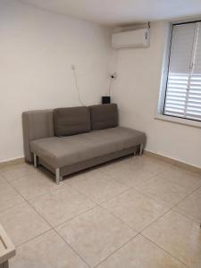 a brown couch in a room with a window at דירה משפחתית מרווחת in Ashkelon