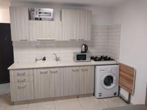 a kitchen with a sink and a washing machine at דירה משפחתית מרווחת in Ashkelon