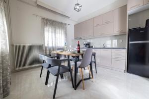 a kitchen with a table and chairs and a refrigerator at Valia's House in Kalabaka