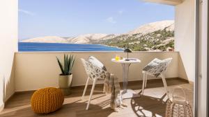 a balcony with a table and chairs and a view of the ocean at Eola Leisure Rooms in Stara Baška