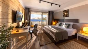 a hotel room with a bed and a desk and a window at Eola Leisure Rooms in Stara Baška