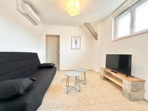 un soggiorno con un divano nero e un tavolo di Le Ronsard - Élégance - Central a Mont-de-Marsan