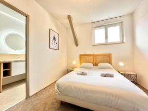 una camera da letto con un grande letto bianco e una finestra di Le Ronsard - Élégance - Central a Mont-de-Marsan