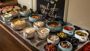 a buffet with bowls of food on a table at Eola Leisure Rooms in Stara Baška